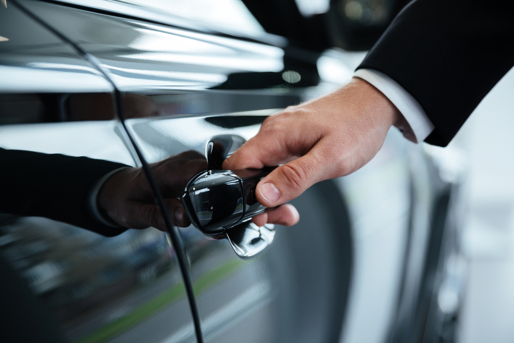 Close up of a male hand opening a car door - Black Car Services - Black Car Services